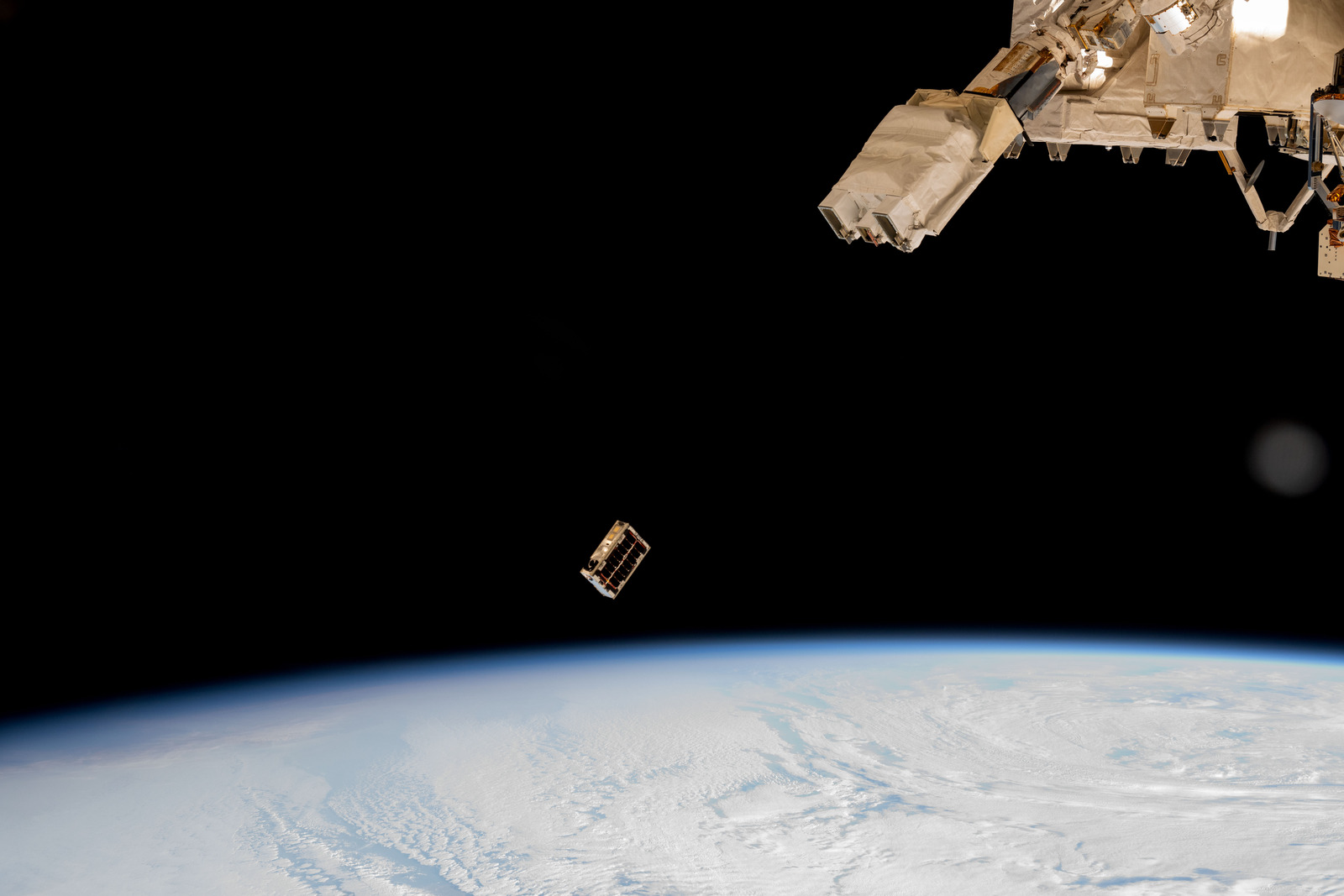 Um CubeSat é ejetado em órbita da Terra, em registro feito da Estação Espacial Internacional